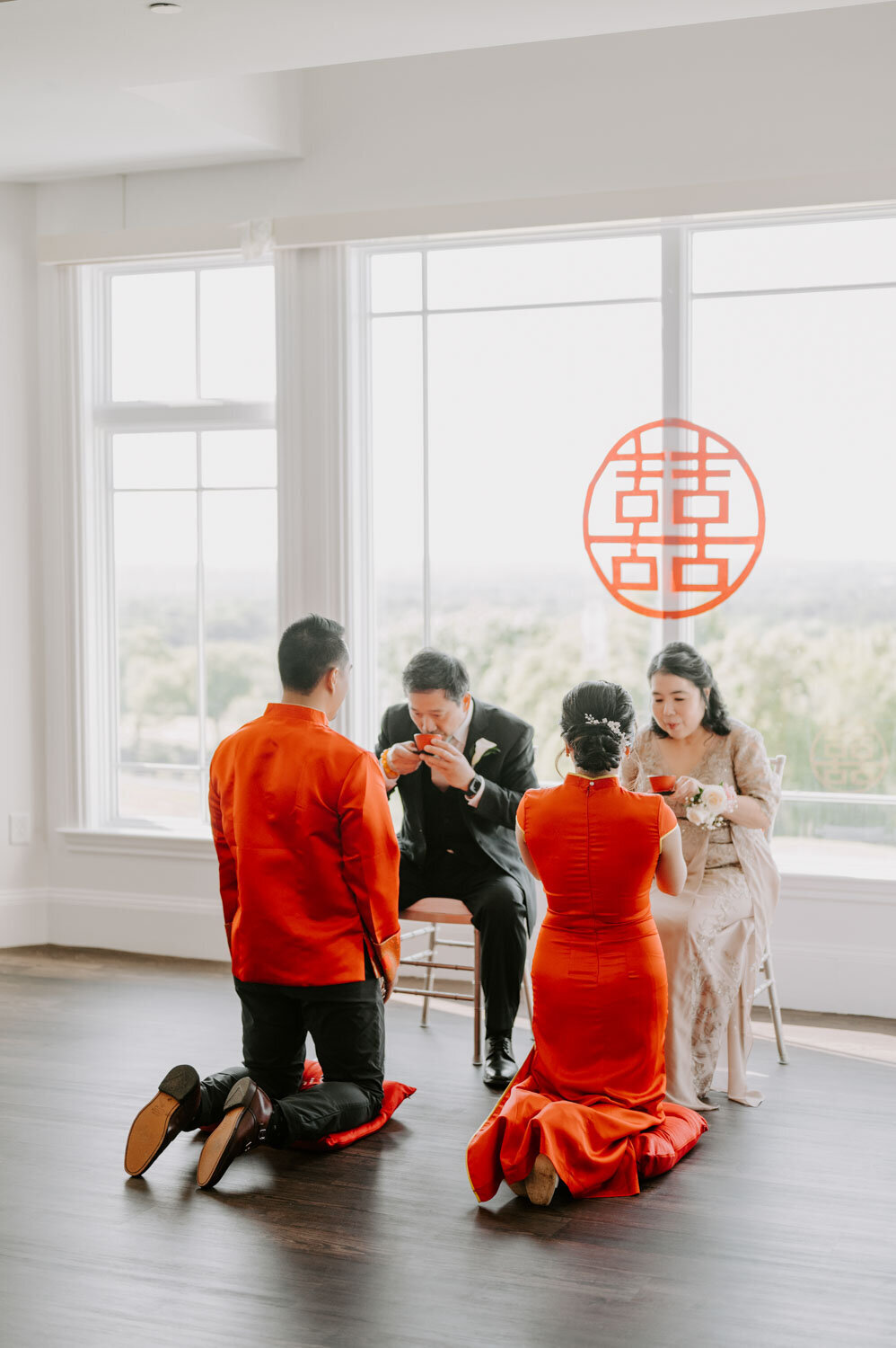 Traditional wedding tea ceremony with the couple kneeling before elders