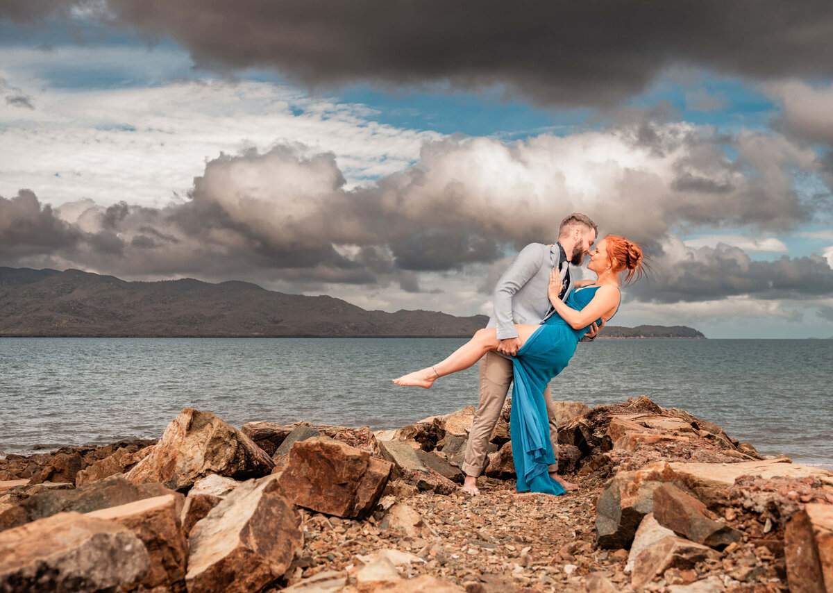 An engaged couple poses together on a beautiful Townsville beach, capturing their love against a stunning natural backdrop - photo by Jamie Simmons