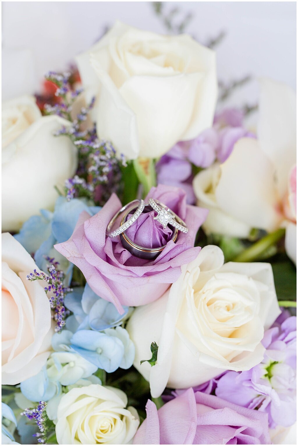wedding rings with purple, white and blue flowers