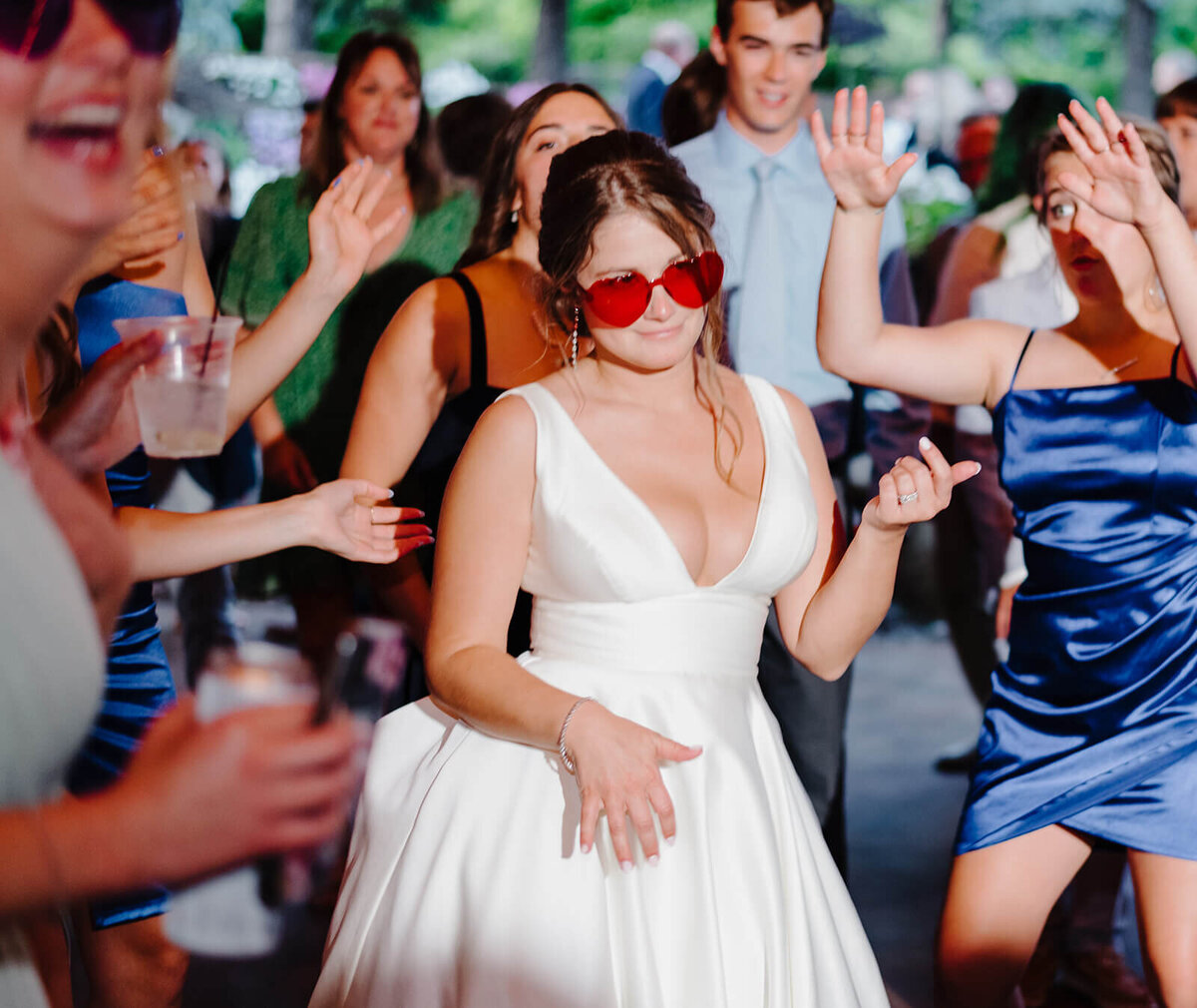Bride wearing red sunglasses at wedding reception