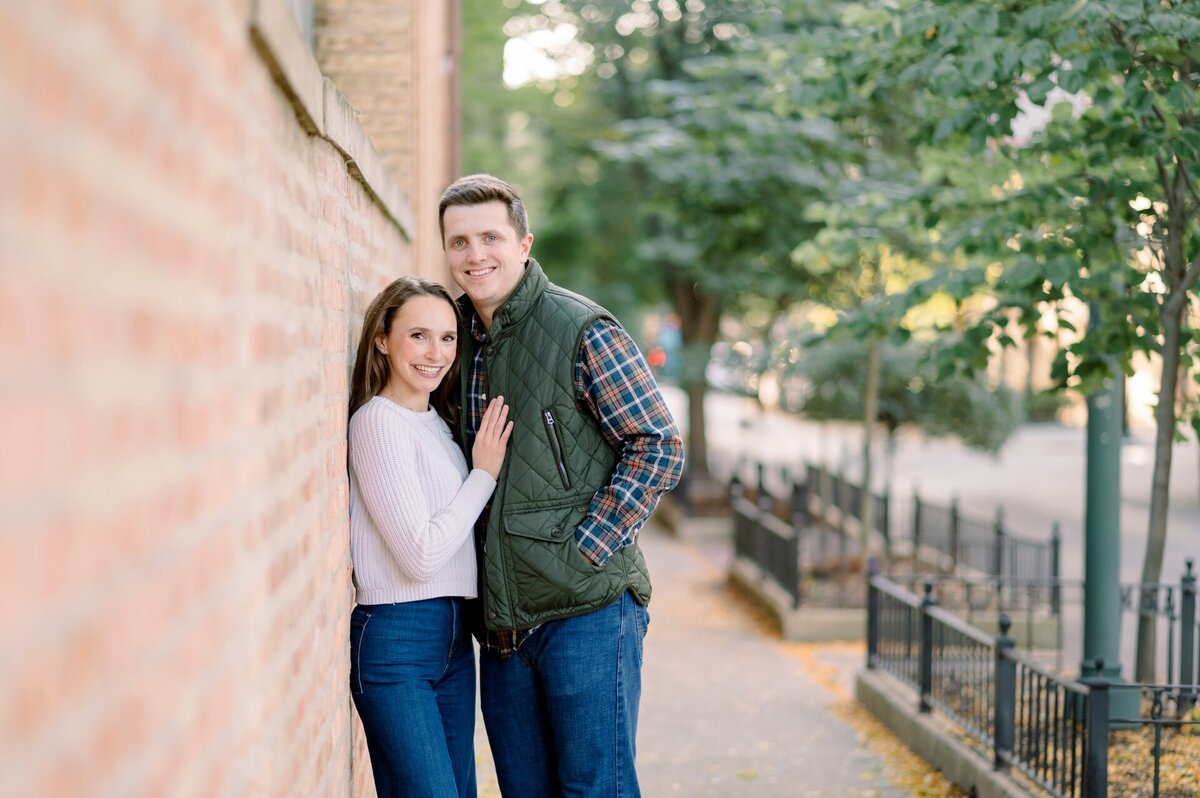 couple posing beside a brick wall in Downtown Chicago