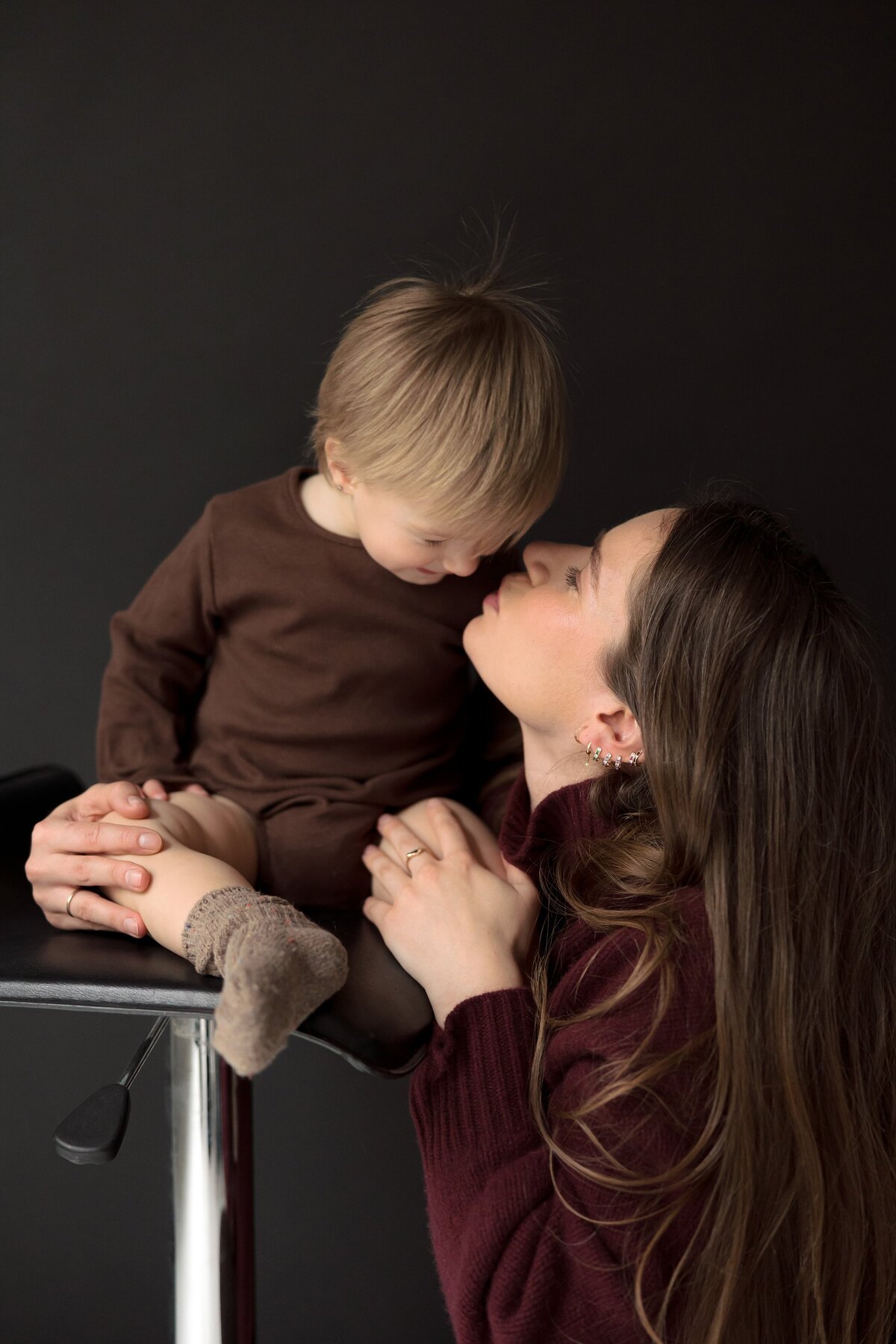 Mother kisses child on the cheek during studio session in Brooklyn.