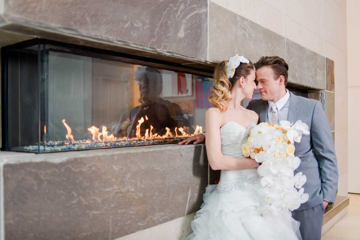 bride and groom posing next to the fireplace at the fairmont hotel