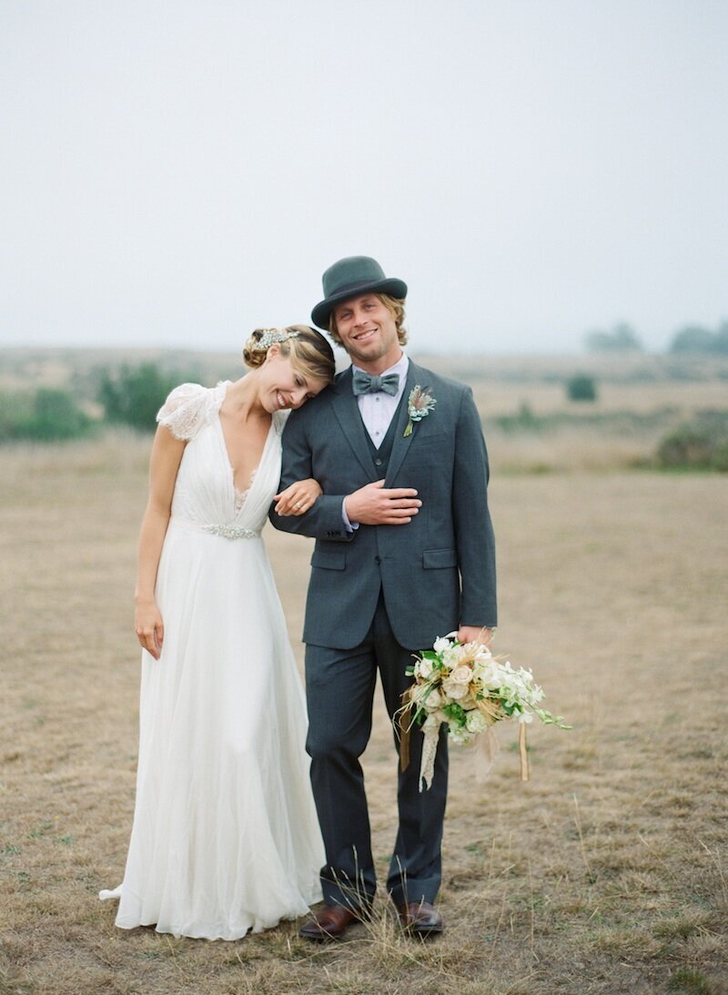 bride and groom standing together holding flowers