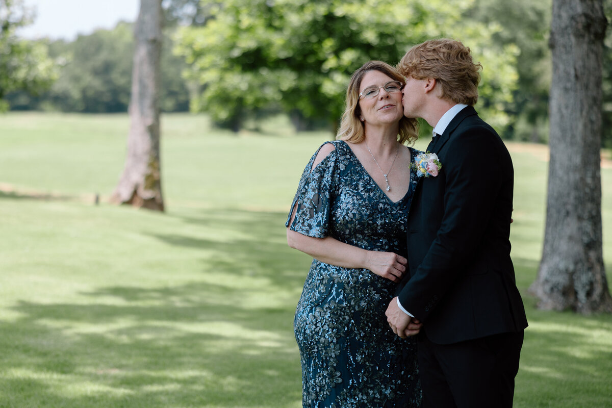 Groom kisses his mother on the cheek