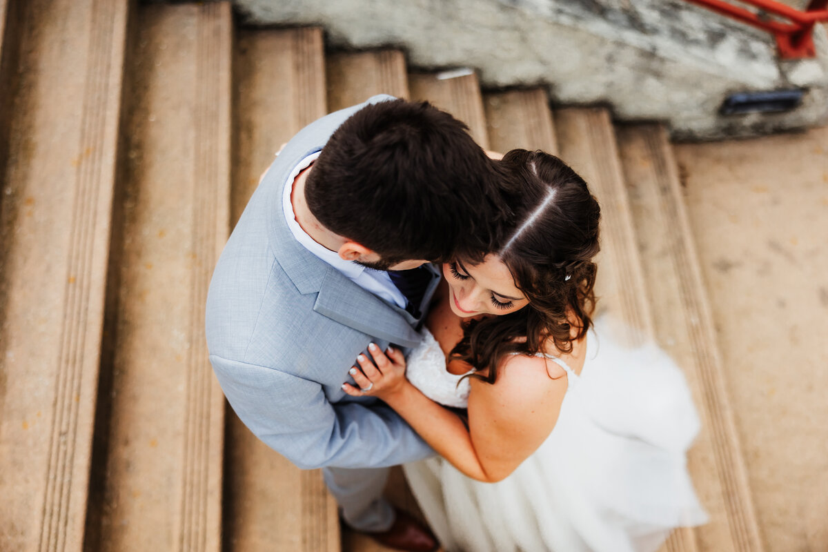 Wedding couple shares an intimate moment on stairs at Wild Onion Brewery.