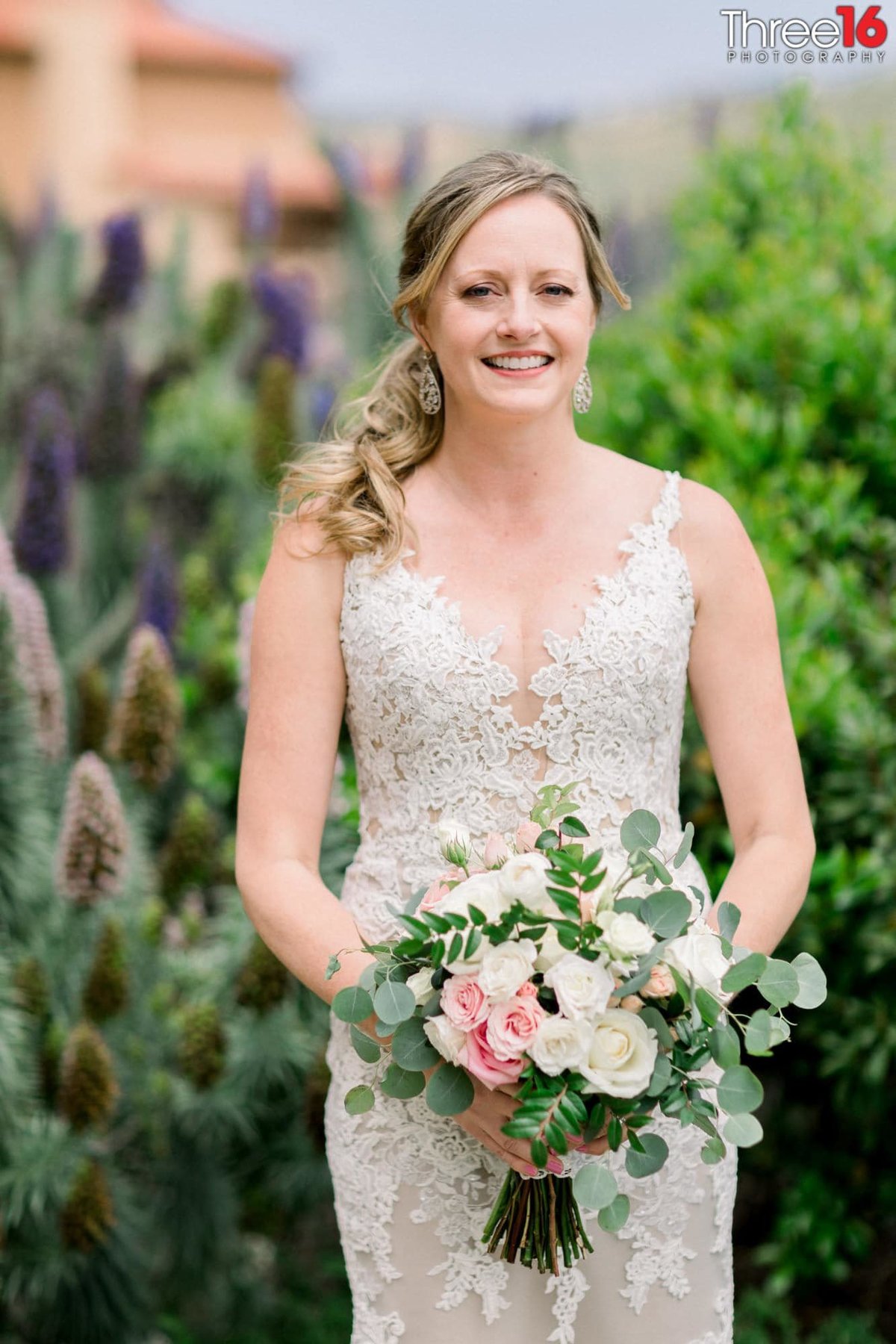 Bride poses with her beautiful bouquet of flowers