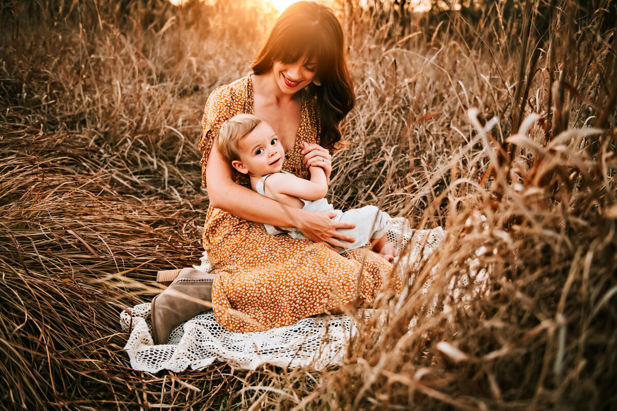 Family Photographer, Mom snuggling her baby boy in the sunset.