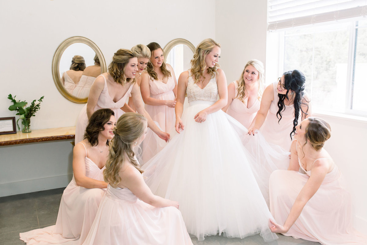 Bridesmaids admiring bride's gown after getting ready at Woodlands Colorado wedding venue