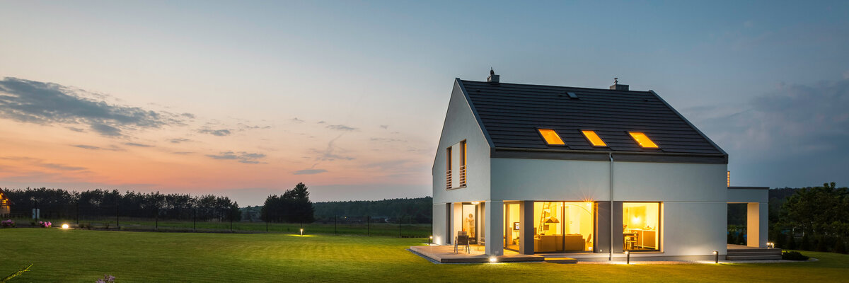 modern, window-filled home exterior at sunset