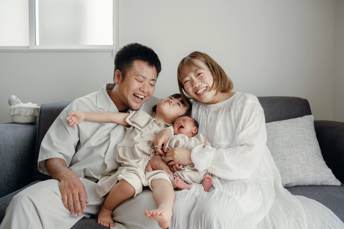 自然な表情で楽しそうに笑う家族写真