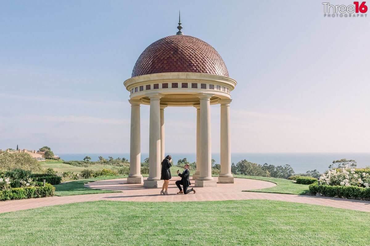 Boyfriend gets down on one knee and proposes to his girlfriend in front of the Italian Rotunda at Pelican Hill Resort.