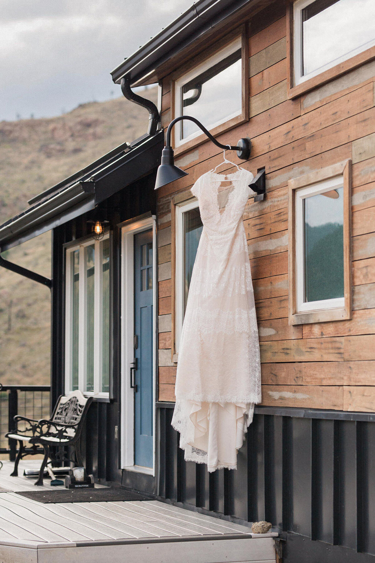 the wedding gown on display, hangs on the light fixture outside of the tiny house that this couple rented in Boulder, Colorado for their wedding