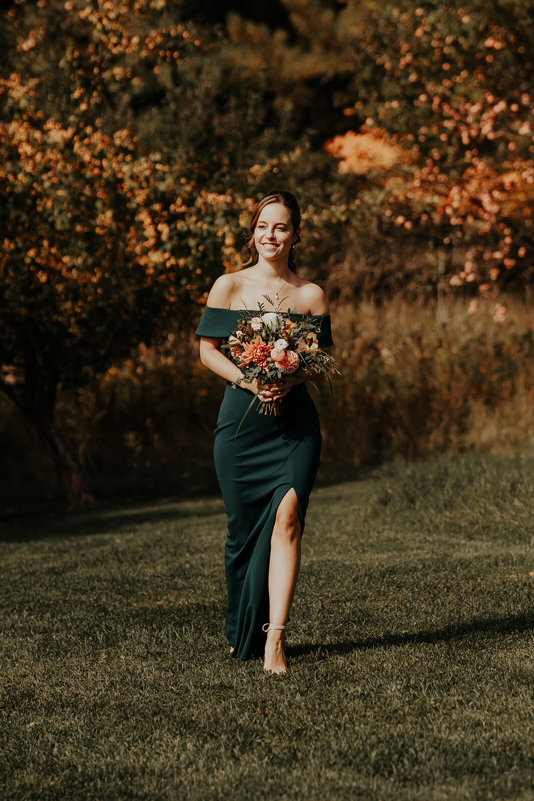 Dark green bridesmaid dress with rust and cream flowers