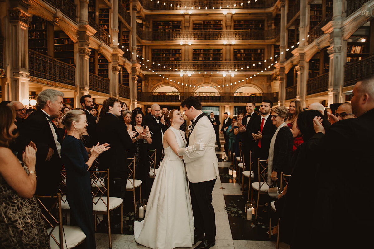 A couple about to kiss as they leave their wedding ceremony 