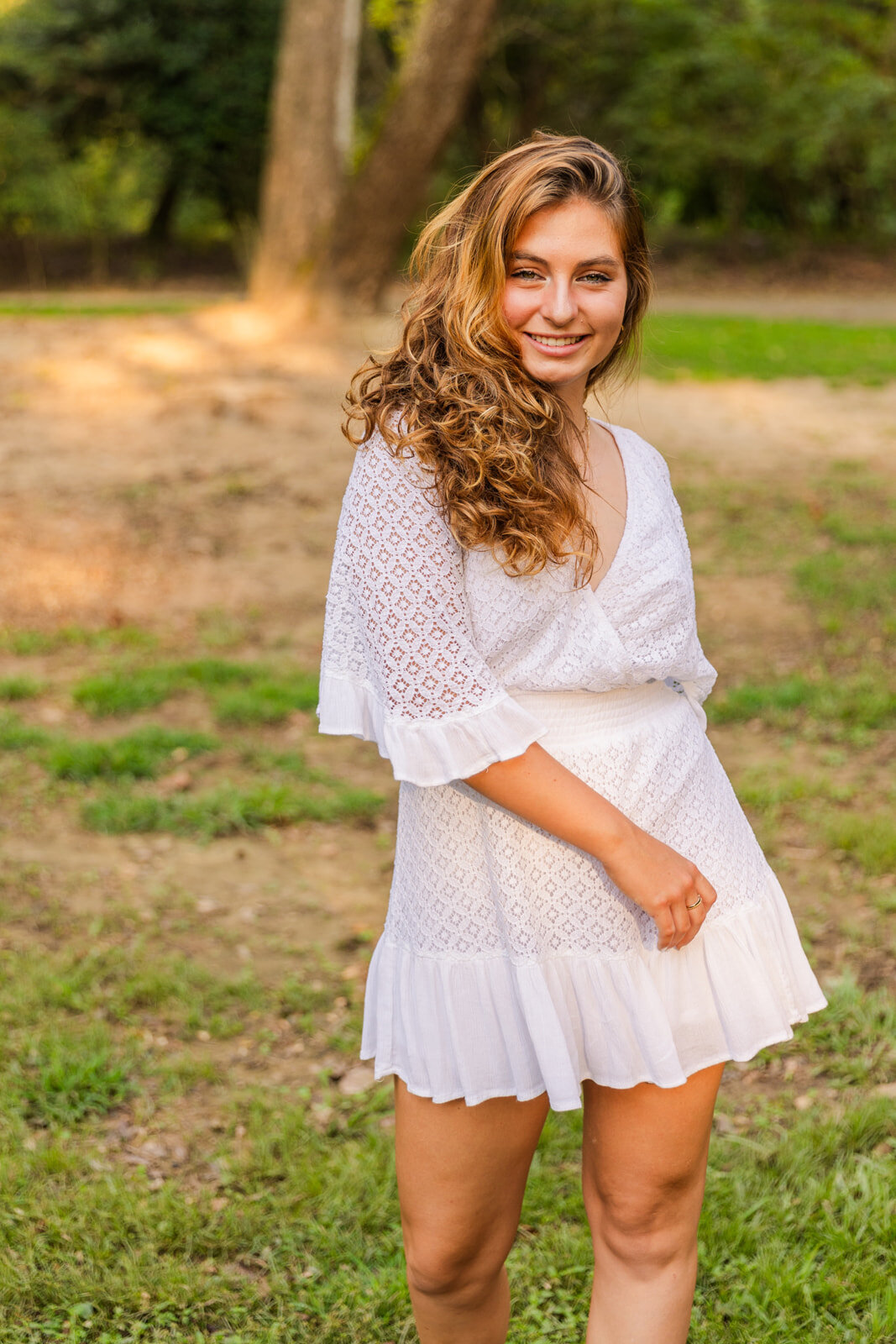 senior girl playing with her white dress in Atlanta park by laure photography