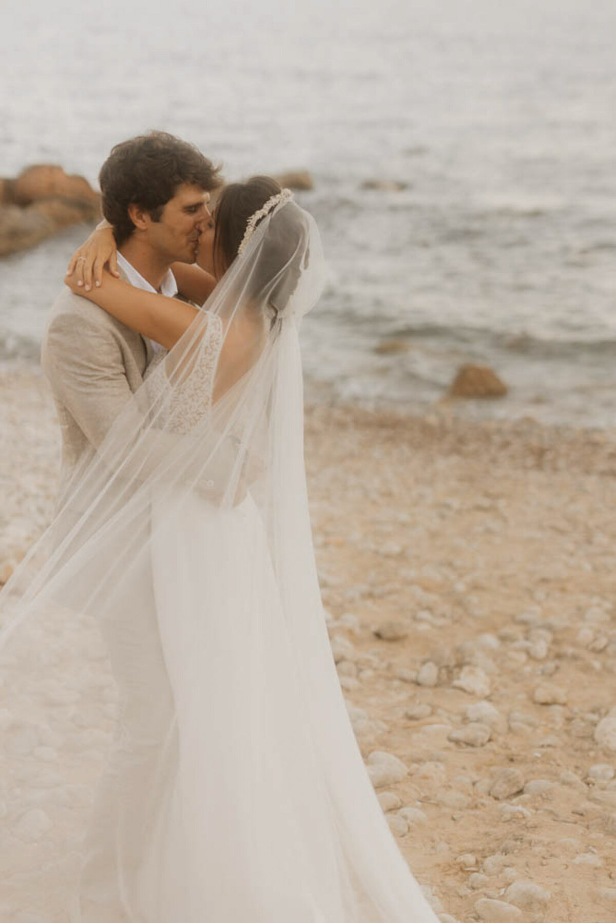 Romantic kiss by the sea during beach wedding in Spain captured by Wedding Photographer Europe