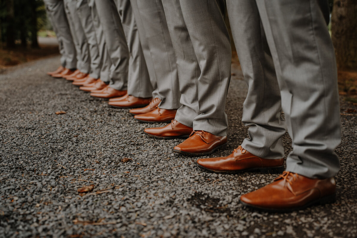 Men lined up with the same brown shoes