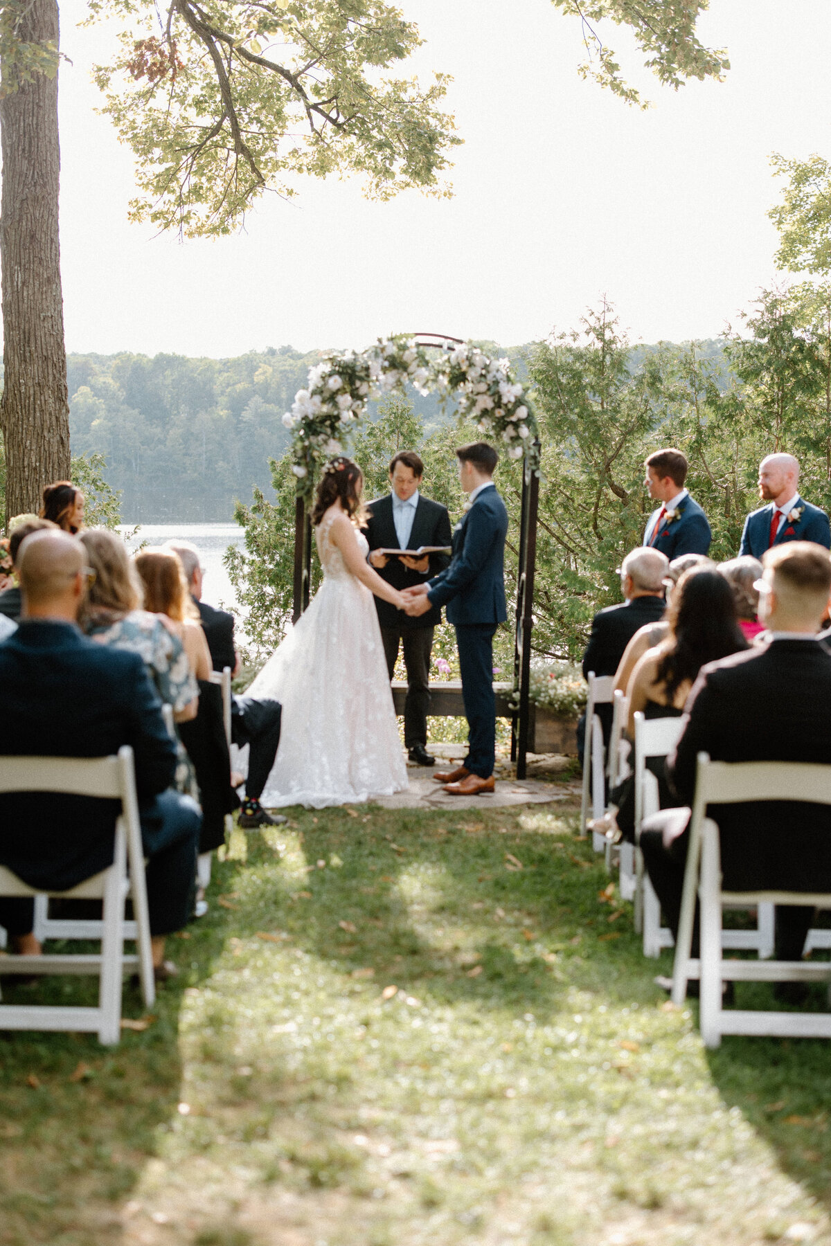 Wide shot of the bride and groom at the altar listening to the pastor