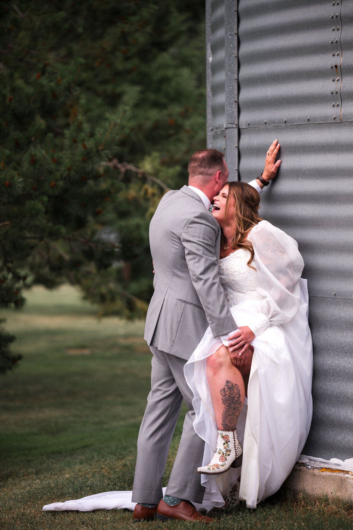 groom whispers in his brides ears and makes her laugh