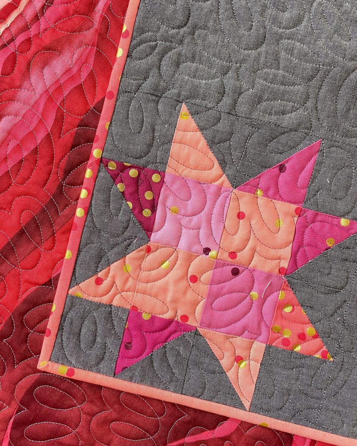 filaments quilting design on a pink star quilt