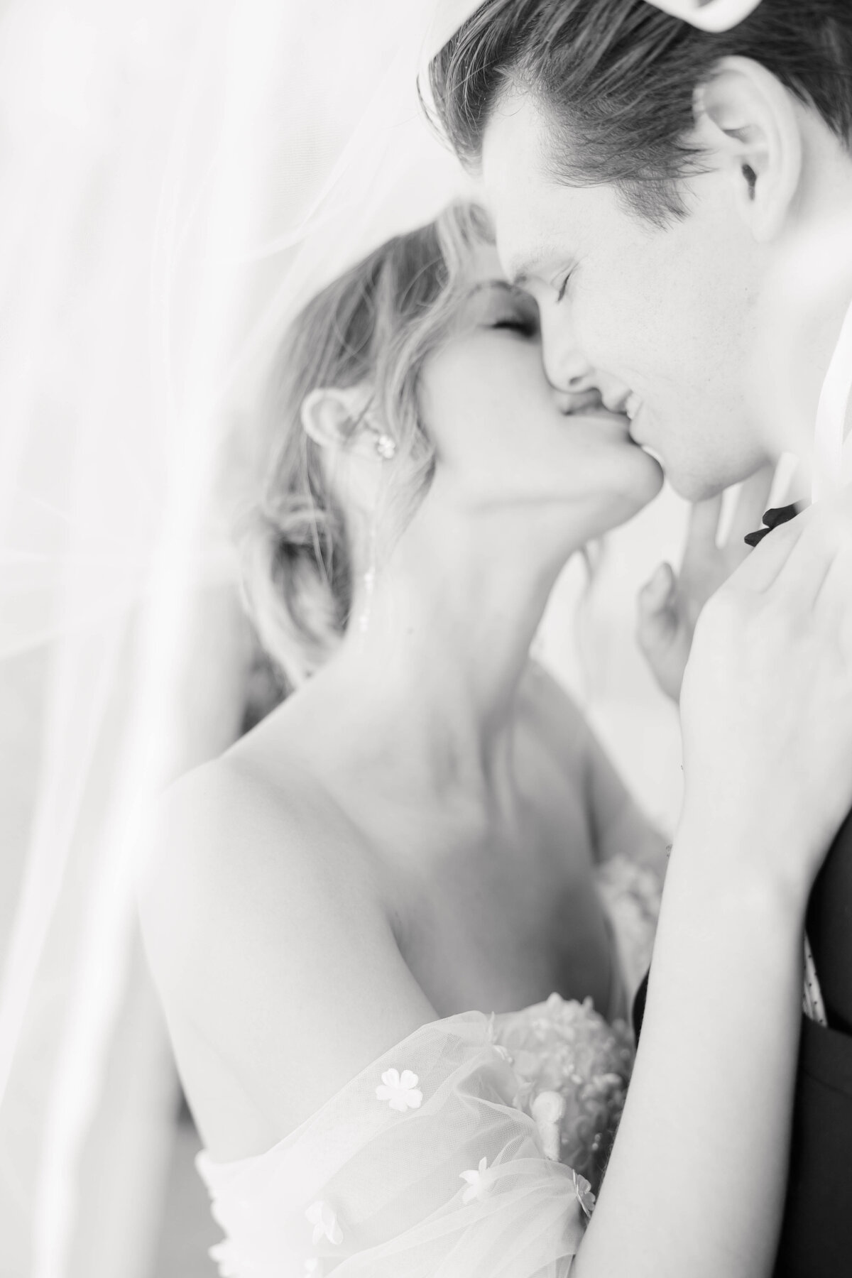 bright light and airy wedding photo of bride and groom rings and invitation