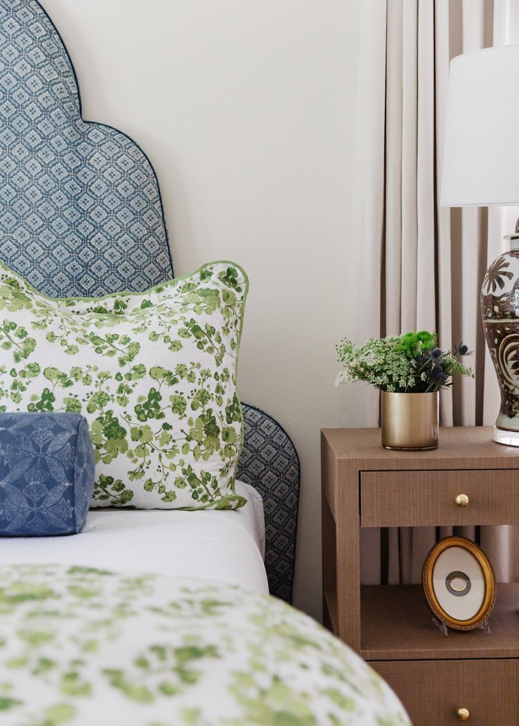 oyster creek studios oak forest remodel wooden accent table with palnt next to blue bedframe with floral bedding in bedroom
