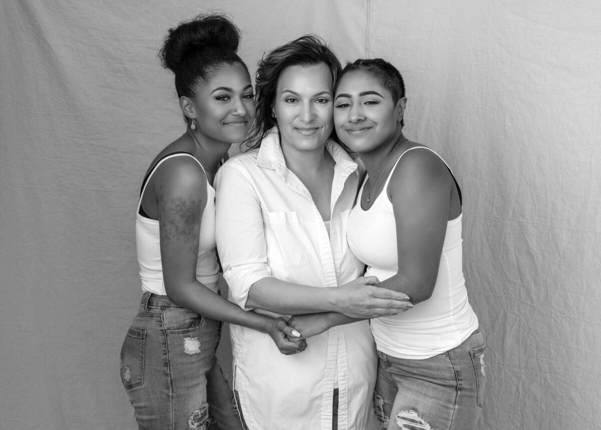 Mother and daughters embracing in black and white.