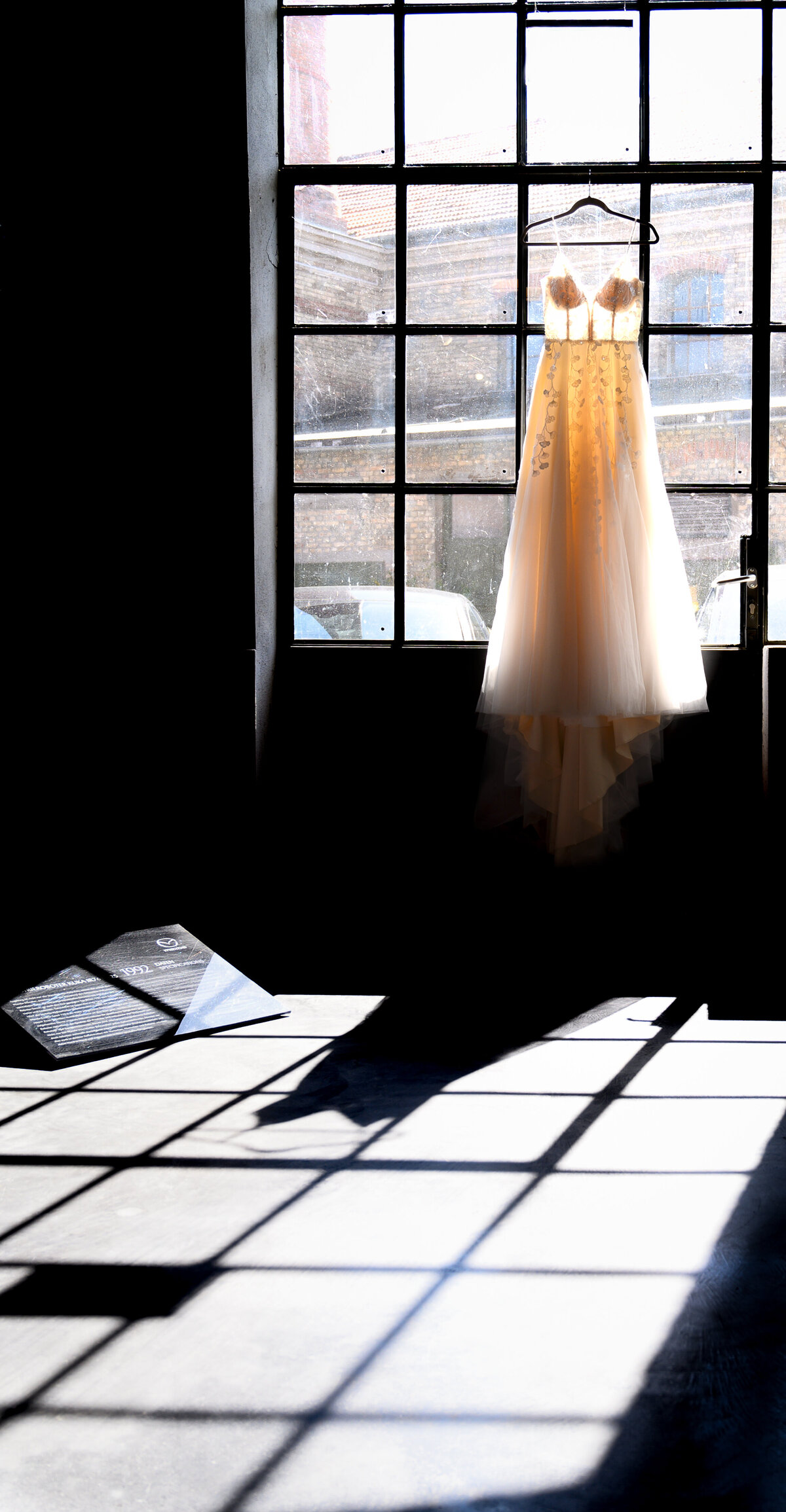 Brautkleid hängt an Glastür