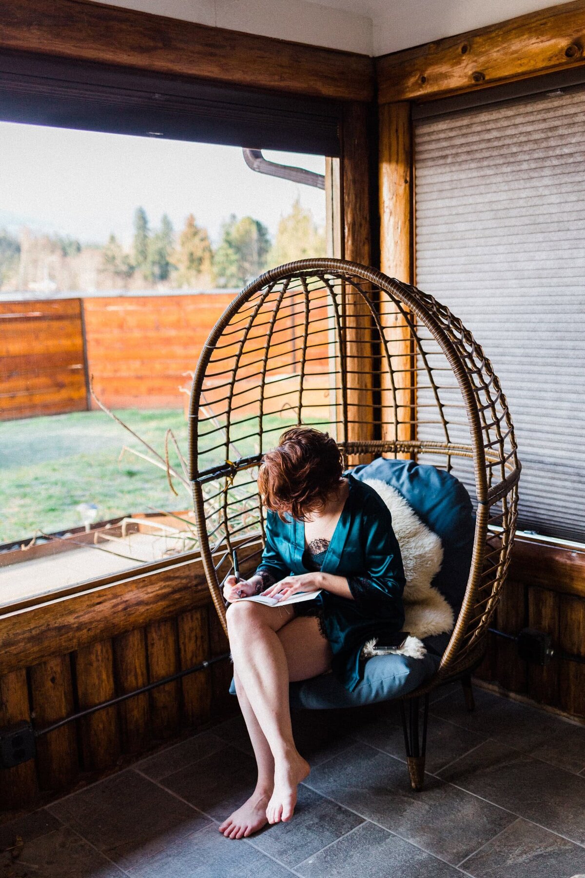 bride writing vows in wicker chair before her Washington Elopement.