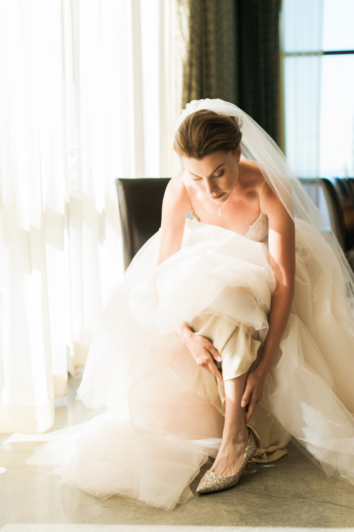 luxury bride putting on jimmy choo shoes at ponzi winery wedding