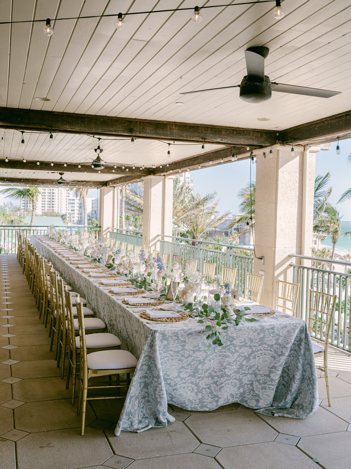 Long feasting table set up for colorful garden beach wedding
