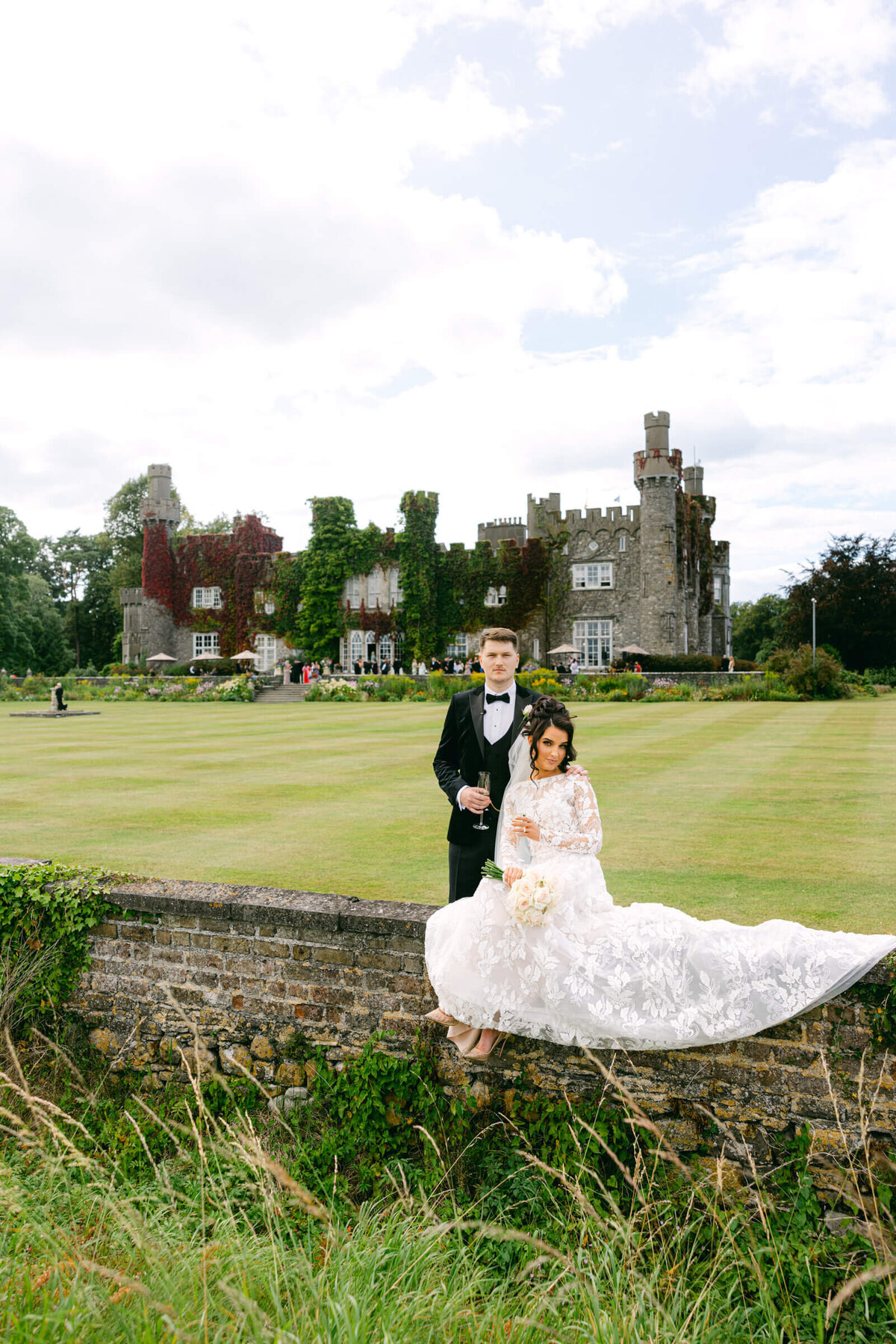 A wedding photo of the bride and groom with Luttrellstown Castle behind them