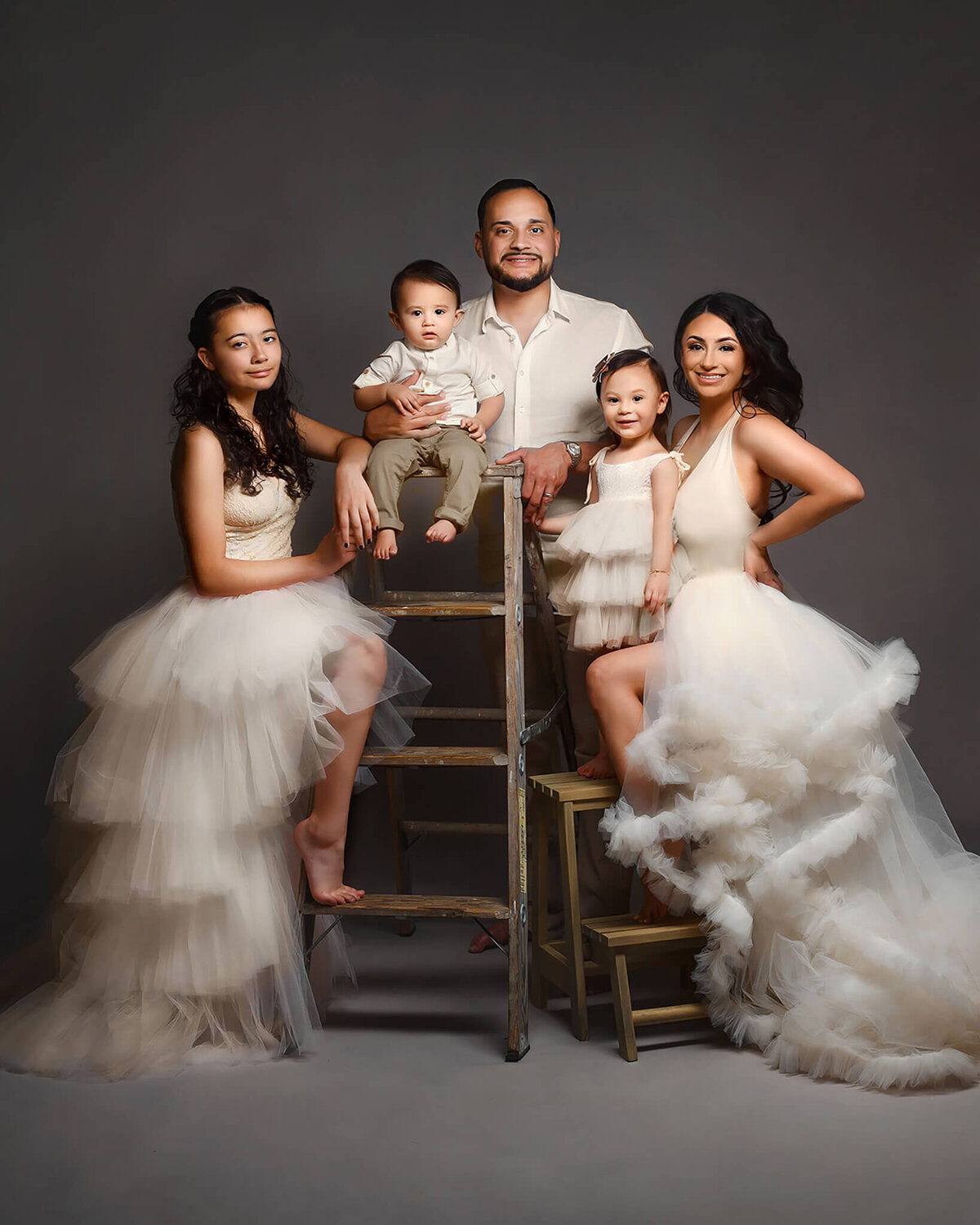 beautiful family in formal attire  posing elegantly against textured gray background