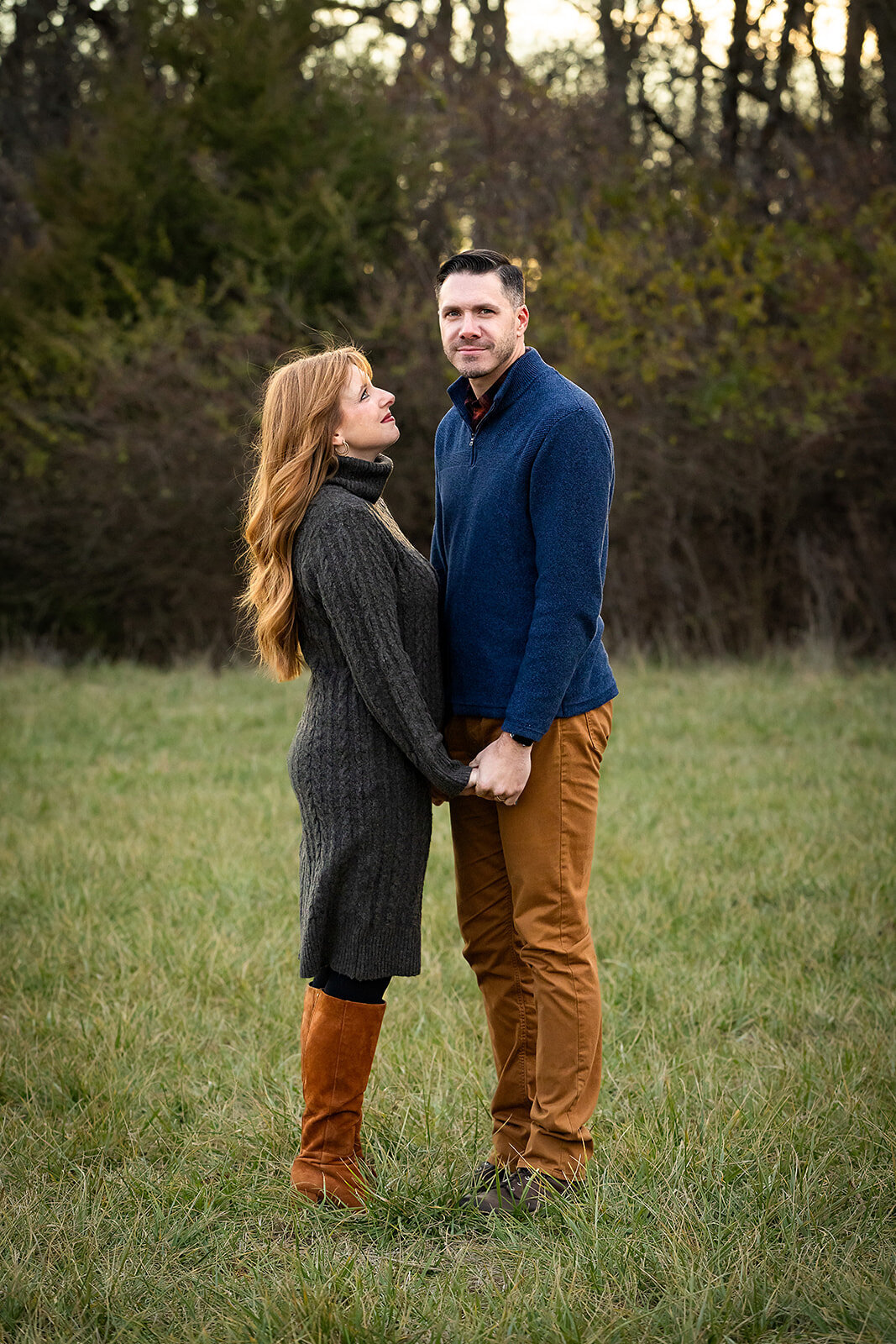 woman looking at man and holding hands with man looking at camera