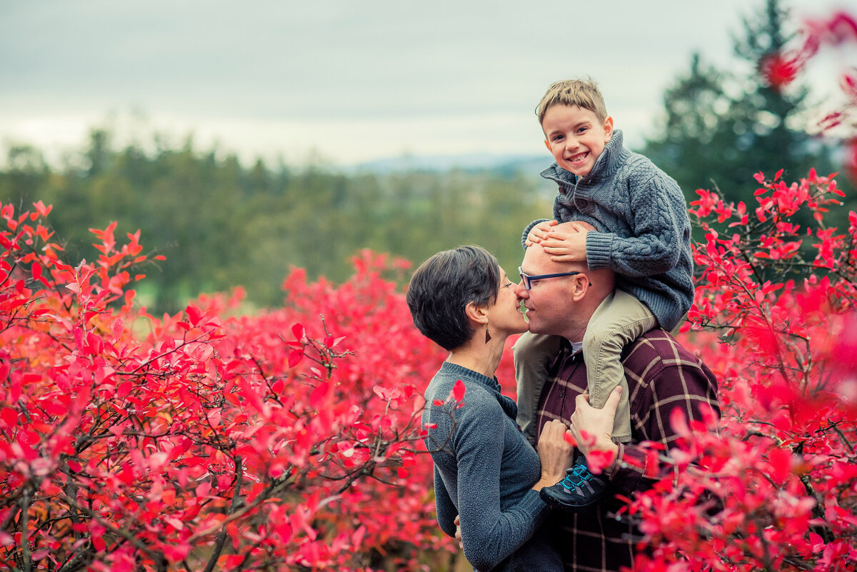 family of three in red leaves