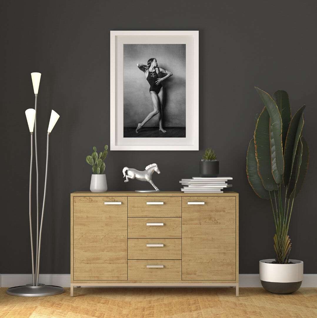 dark grey wall with white framed photo of dancer