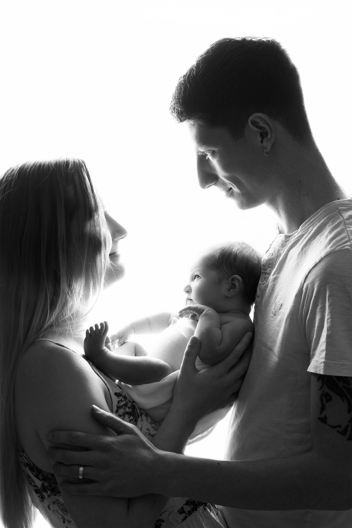 Studio backlit portrait of parents admiring their newborn baby | Family photography Paris Ontario