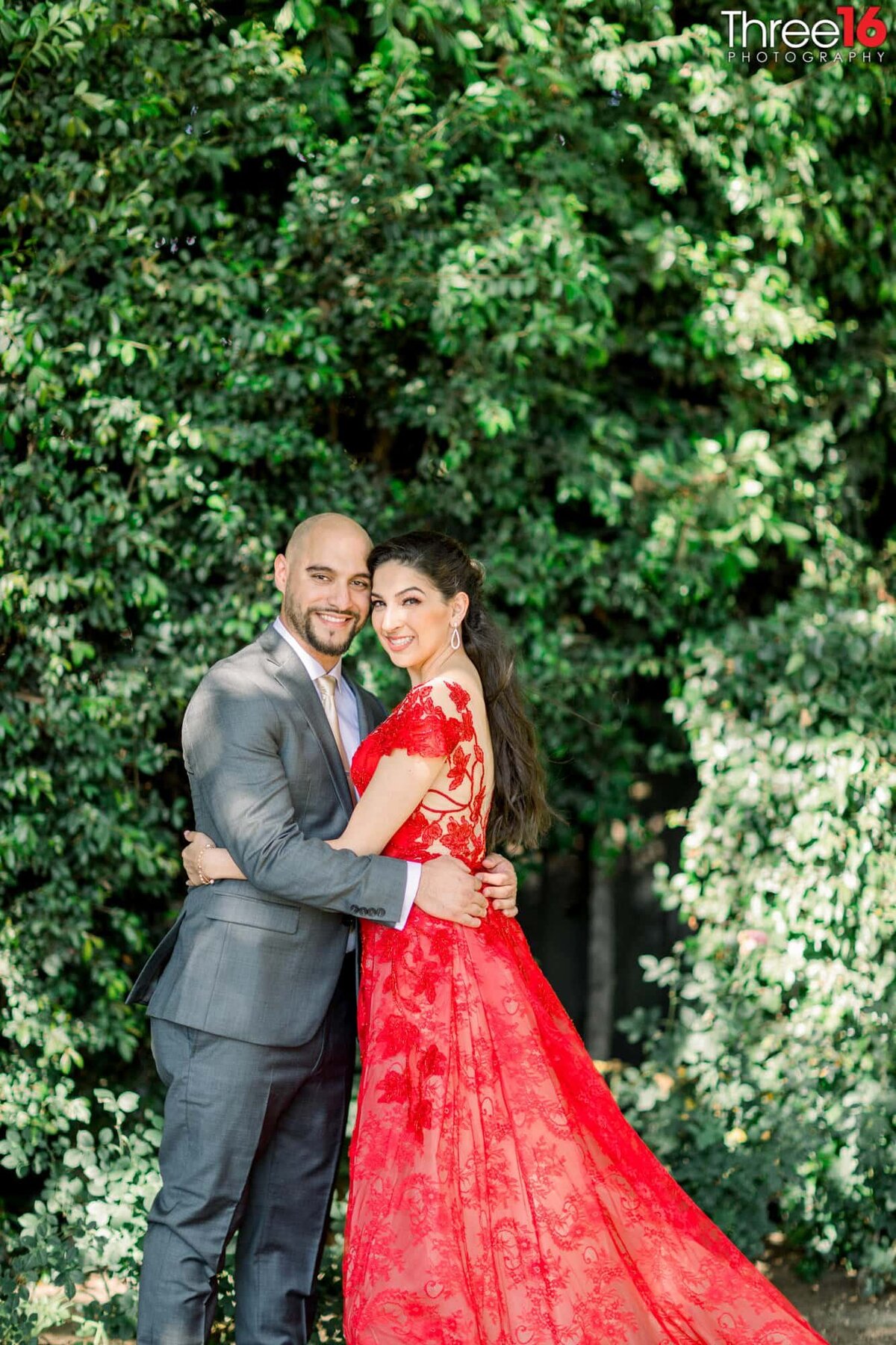 Bride to be dons a beautiful red dress as she embraces her Groom