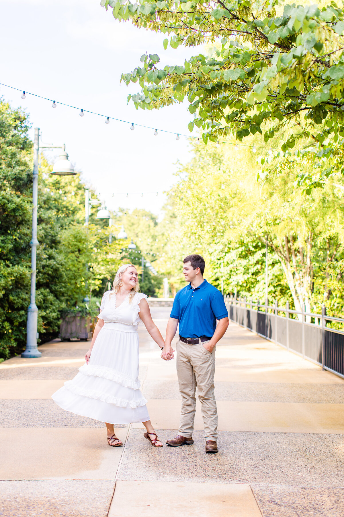girl swinging white dress holding hands with her fiance