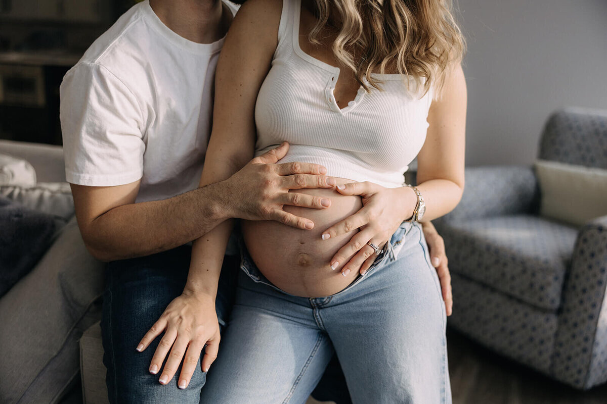 Man holding his wifes belly for a maternity session