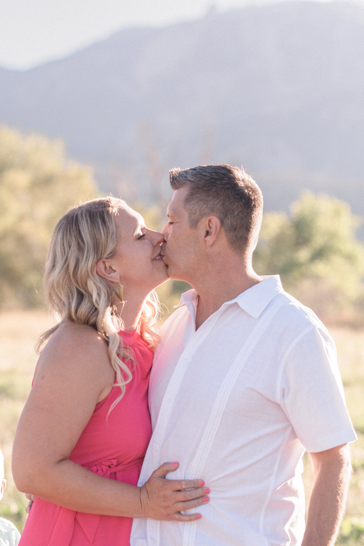 A couple kiss with El Dorado Canyon and Devils Thumb in the background