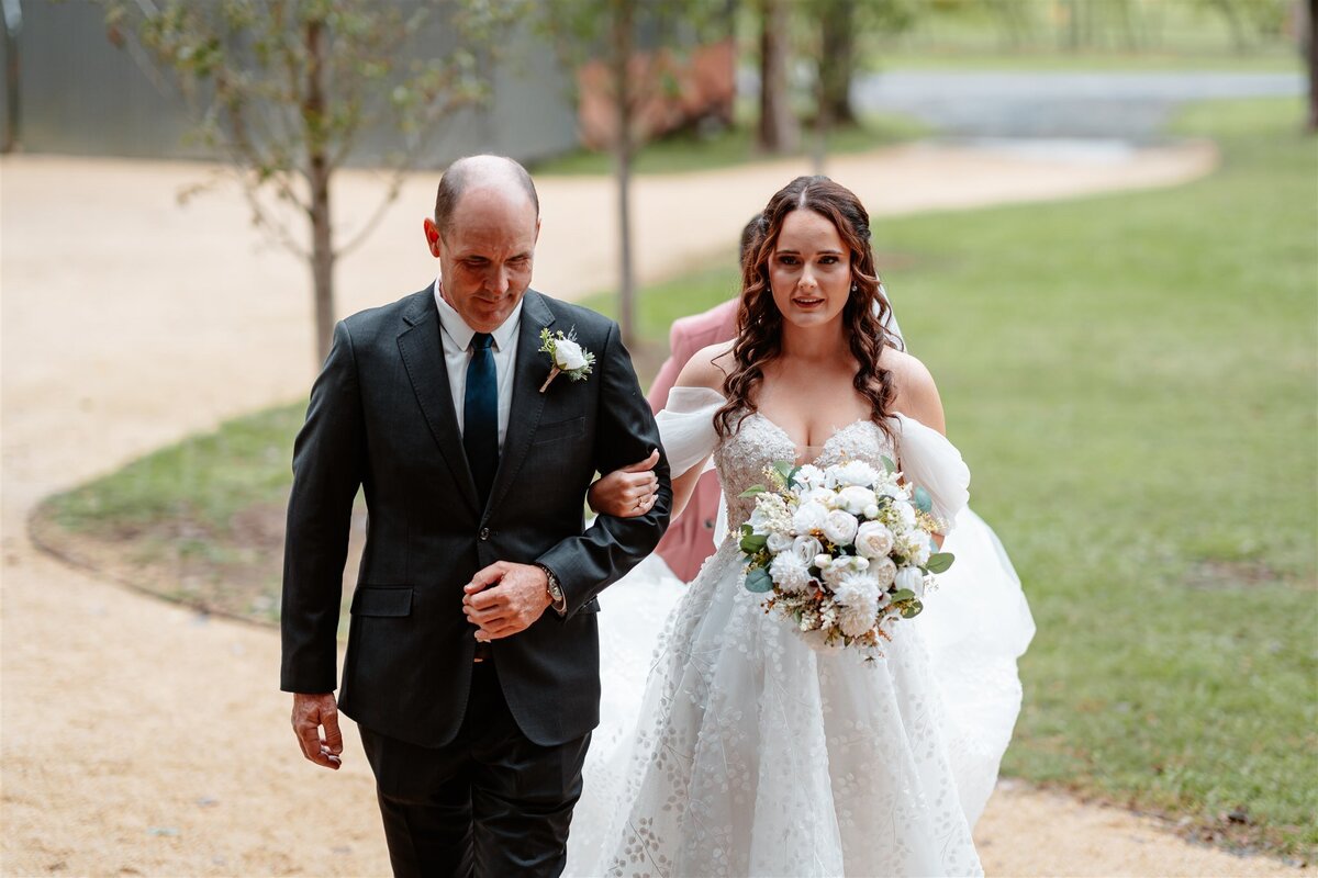 A bride gracefully walks towards her groom, radiating joy and anticipation.