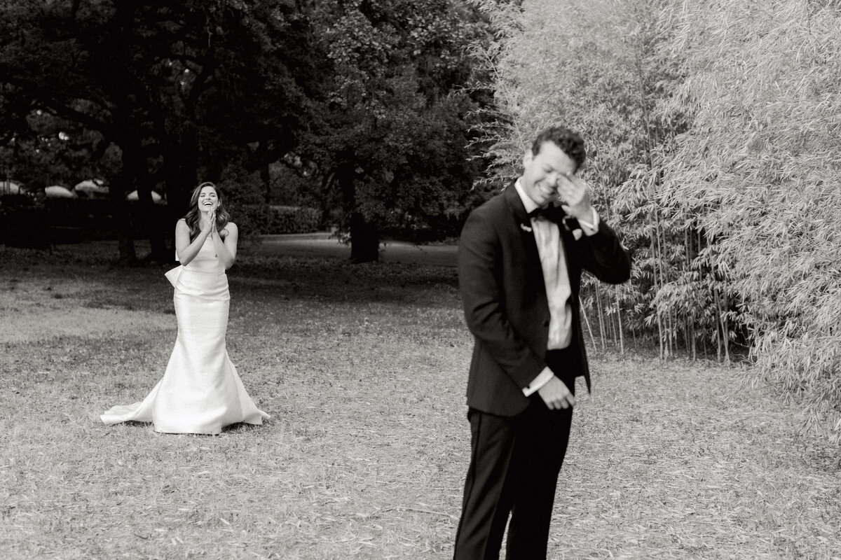 bride approaching groom from behind wedding first look crying black and white