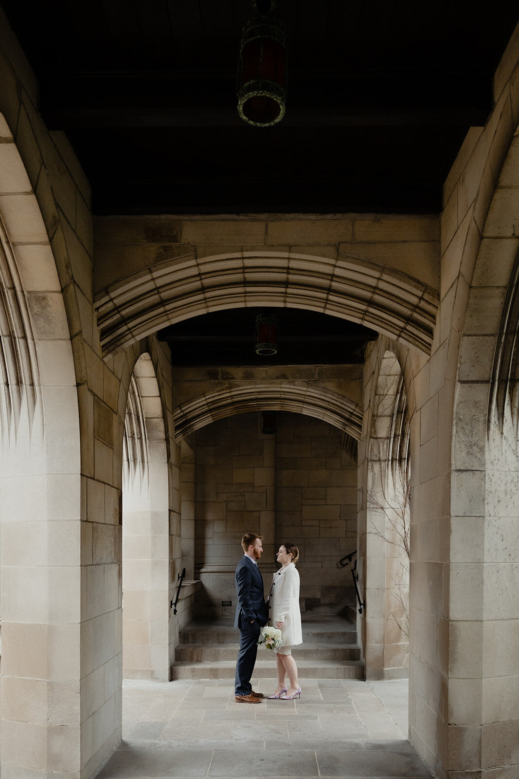 Just Married photo session couple stands in Chicago church cloister very close and looks at each other