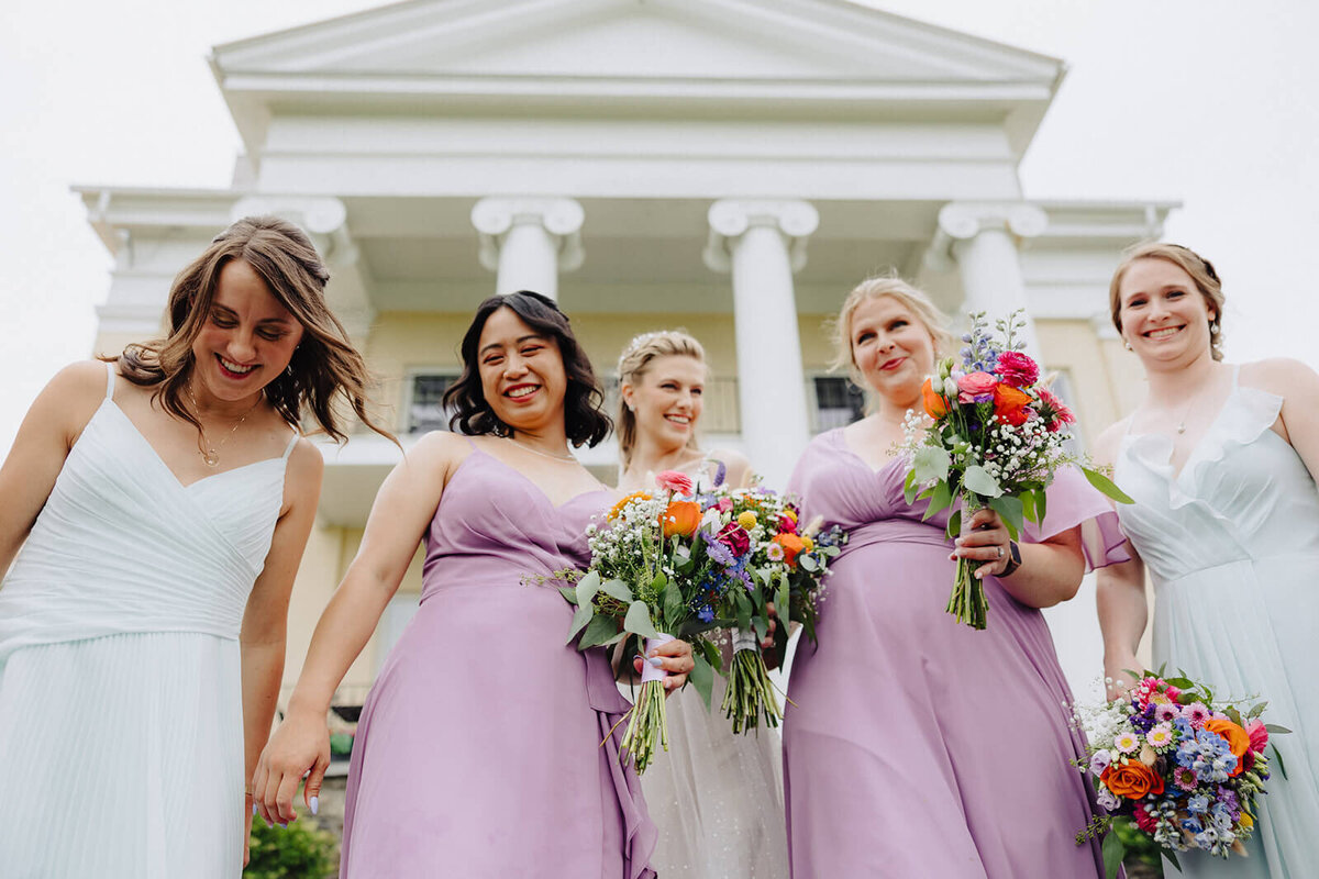 Bride with bridesmaids looking down at camera at Mansion at Keuka Lake, NY