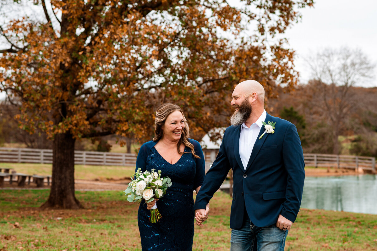 Newlyweds holding hands walking during their elopement in the fall weather
