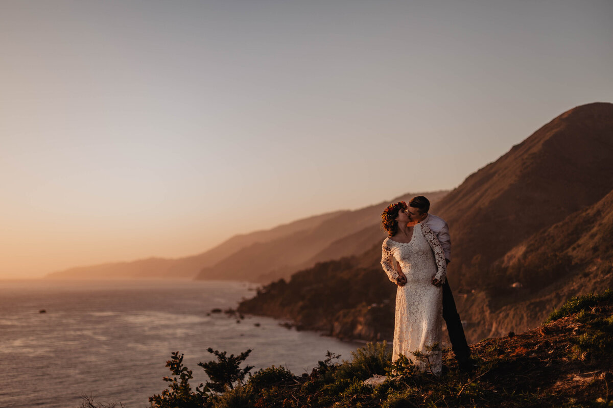 Bride and groom standing on edge of cliff in Big Sur, California