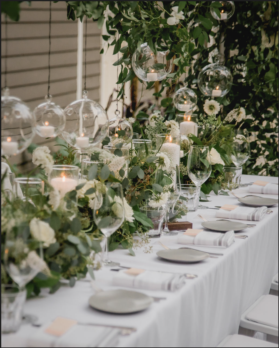 Summery outdoor event with white flowers, neutral décor, and long guest tables at Hasbrouck House, a boutique event venue in Upstate NY.