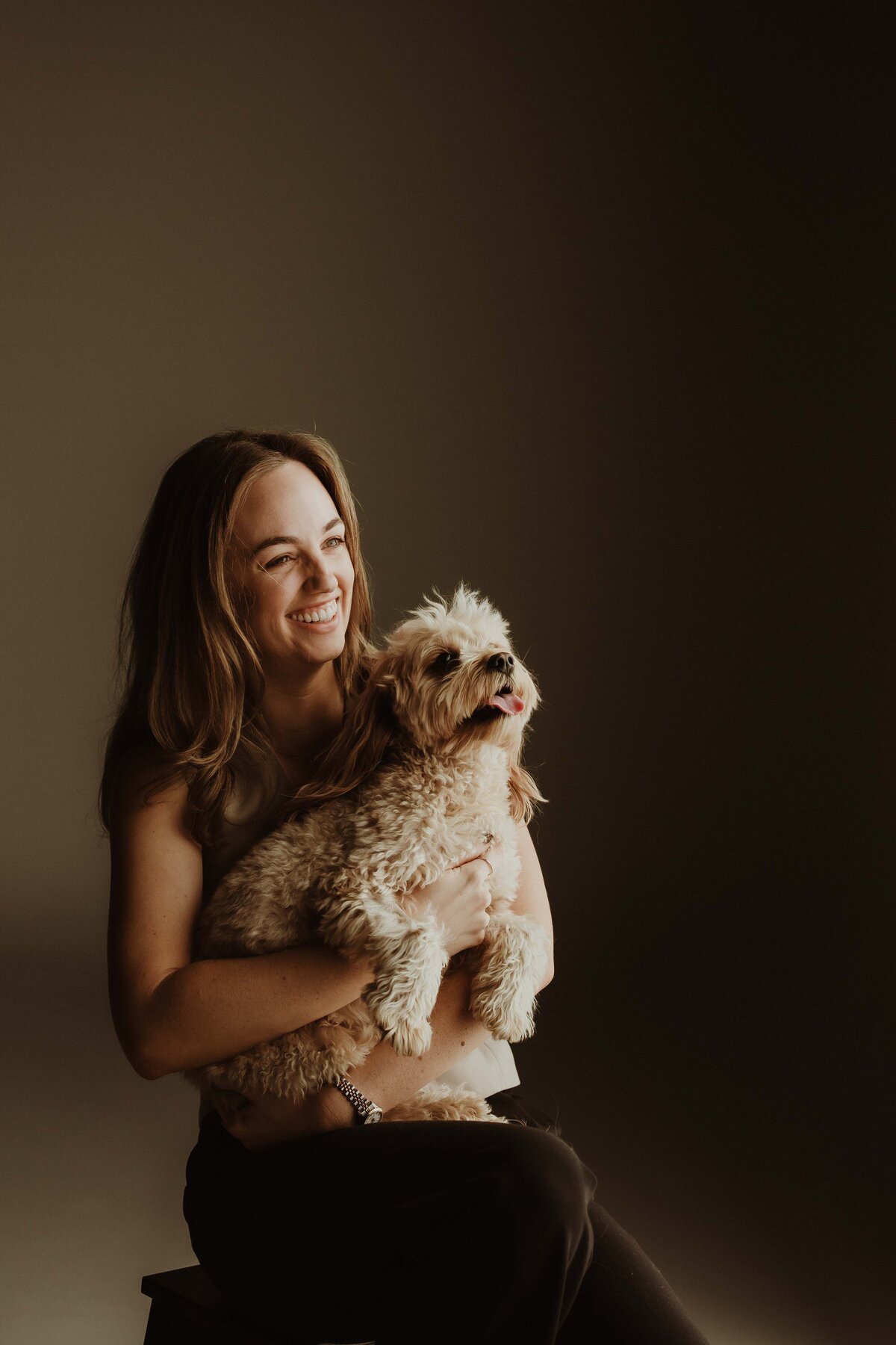 Woman holding a dog and laughing in a Sydney studio session